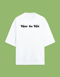 A white short-sleeve t-shirt with the phrase 'Wear the Wild' printed in black across the chest, displayed against a solid light green background.