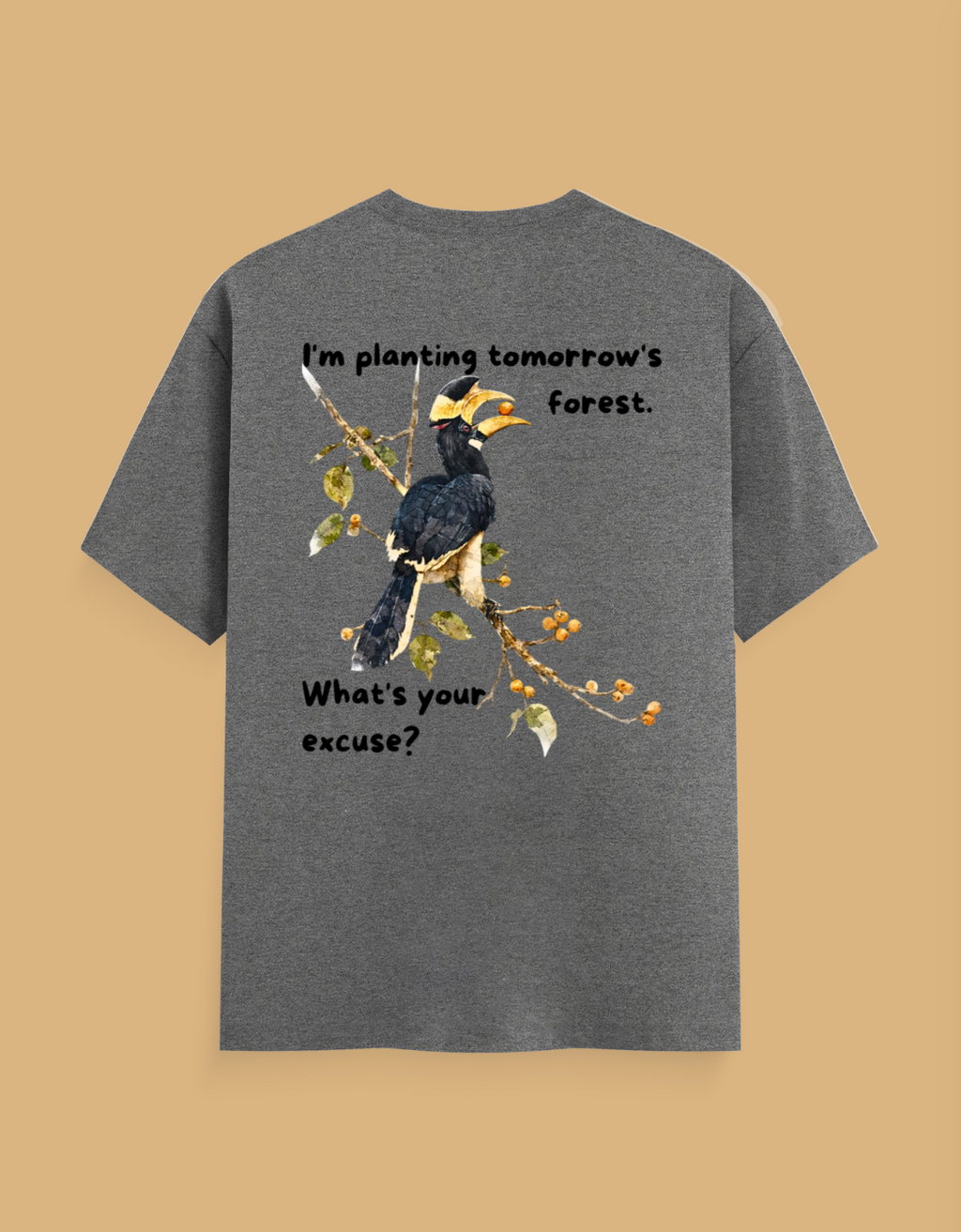 A heather gray short-sleeve t-shirt with a graphic of a hornbill bird on a branch, featuring the text 'I'm planting tomorrow's forest. What's your excuse?' on a solid tan background.