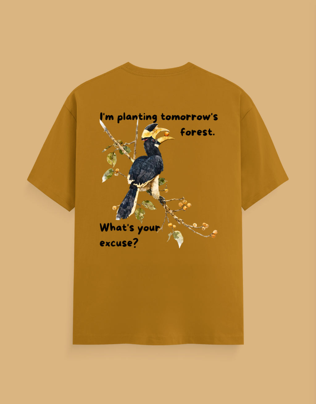 A mustard yellow t-shirt with a graphic of a hornbill bird on a branch, featuring the text 'I'm planting tomorrow's forest. What's your excuse?' on a solid beige background.