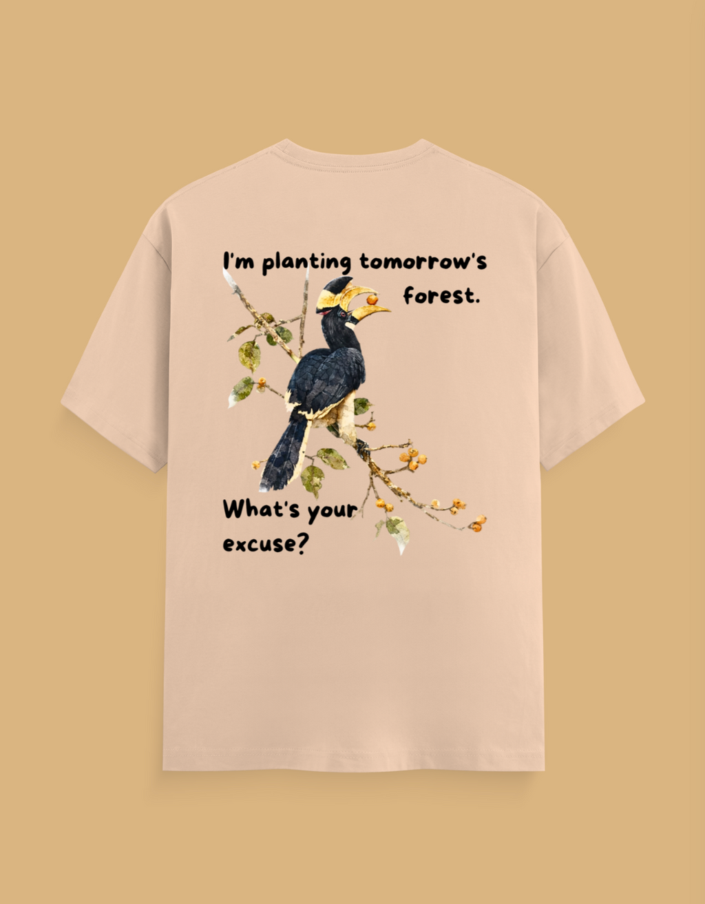 A beige short-sleeve t-shirt shown from the back, featuring a graphic of a black and yellow bird on a branch with the text 'I'm planting tomorrow's forest. What's your excuse?' on a solid tan background.