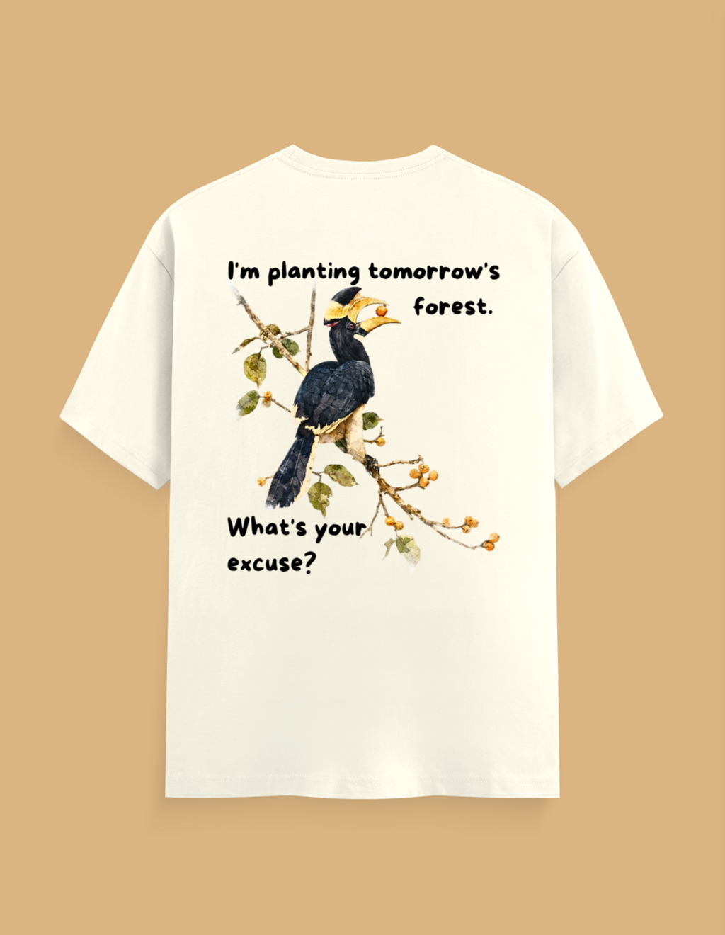 An off-white short-sleeve t-shirt shown from the back, featuring a graphic of a hornbill bird on a branch with the text 'I'm planting tomorrow's forest. What's your excuse?' in black lettering, set against a solid tan background.