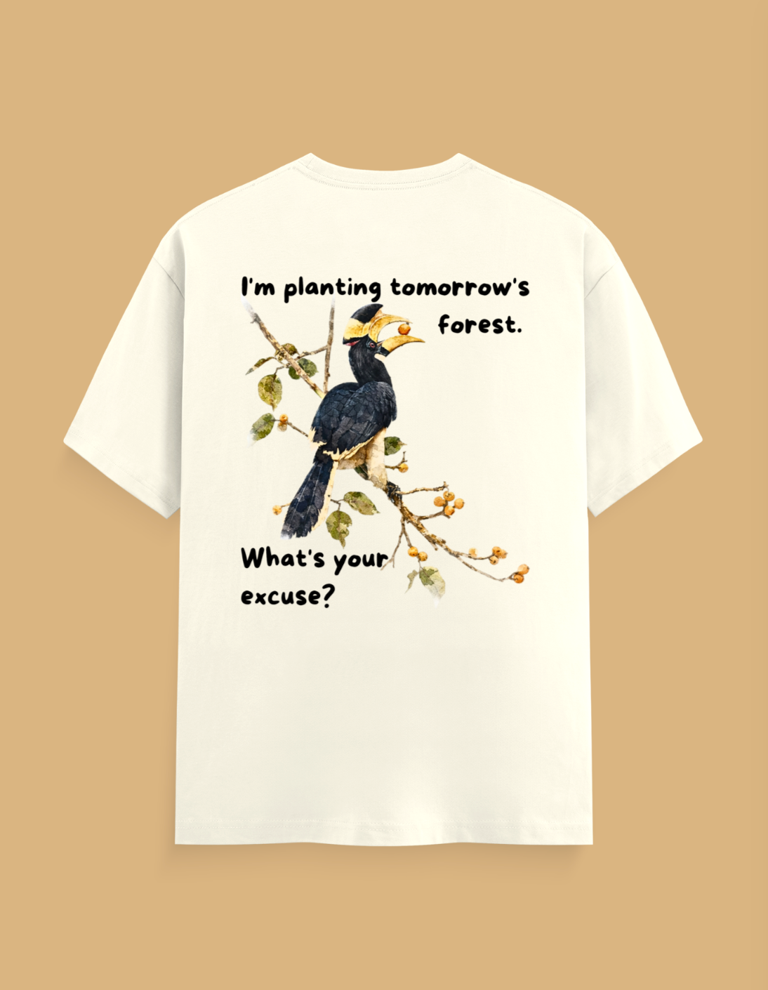 An off-white short-sleeve t-shirt shown from the back, featuring a graphic of a hornbill bird on a branch with the text 'I'm planting tomorrow's forest. What's your excuse?' in black lettering, set against a solid tan background.