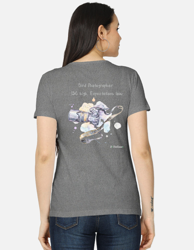 A woman shown from the back wearing a heather gray t-shirt with a graphic print of a camera and the text 'Grid Photographer ISO high, Exposure low.' on a light gray background.